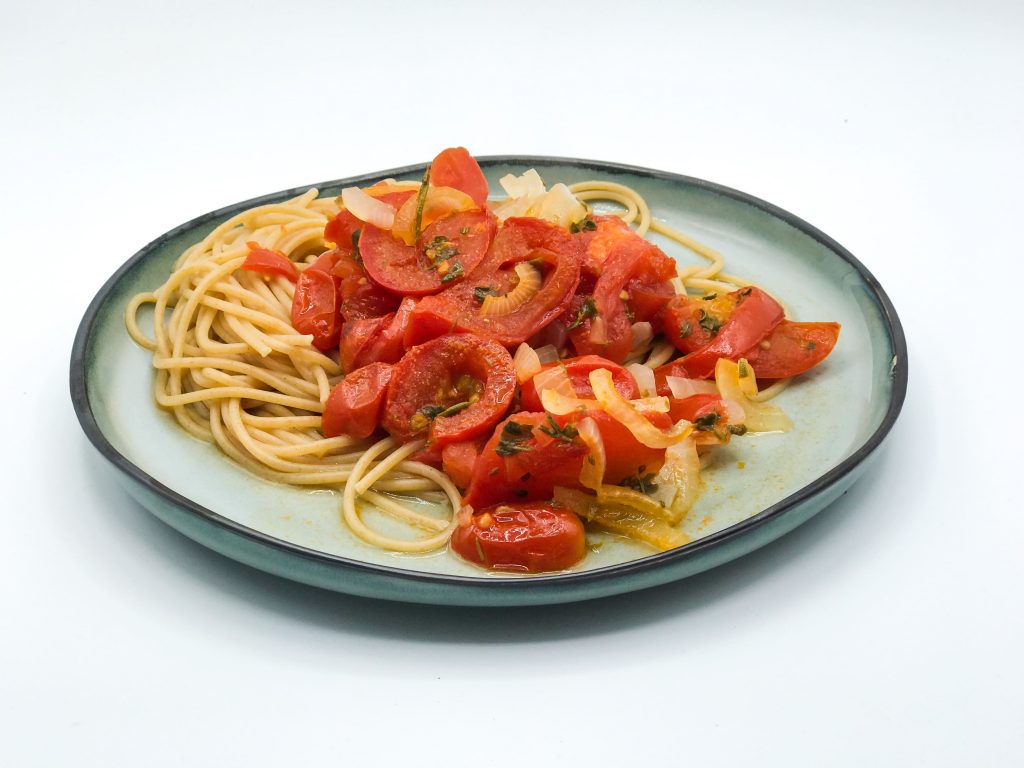 Ein Teller mit Spaghetti, darüber die Ofentomaten.