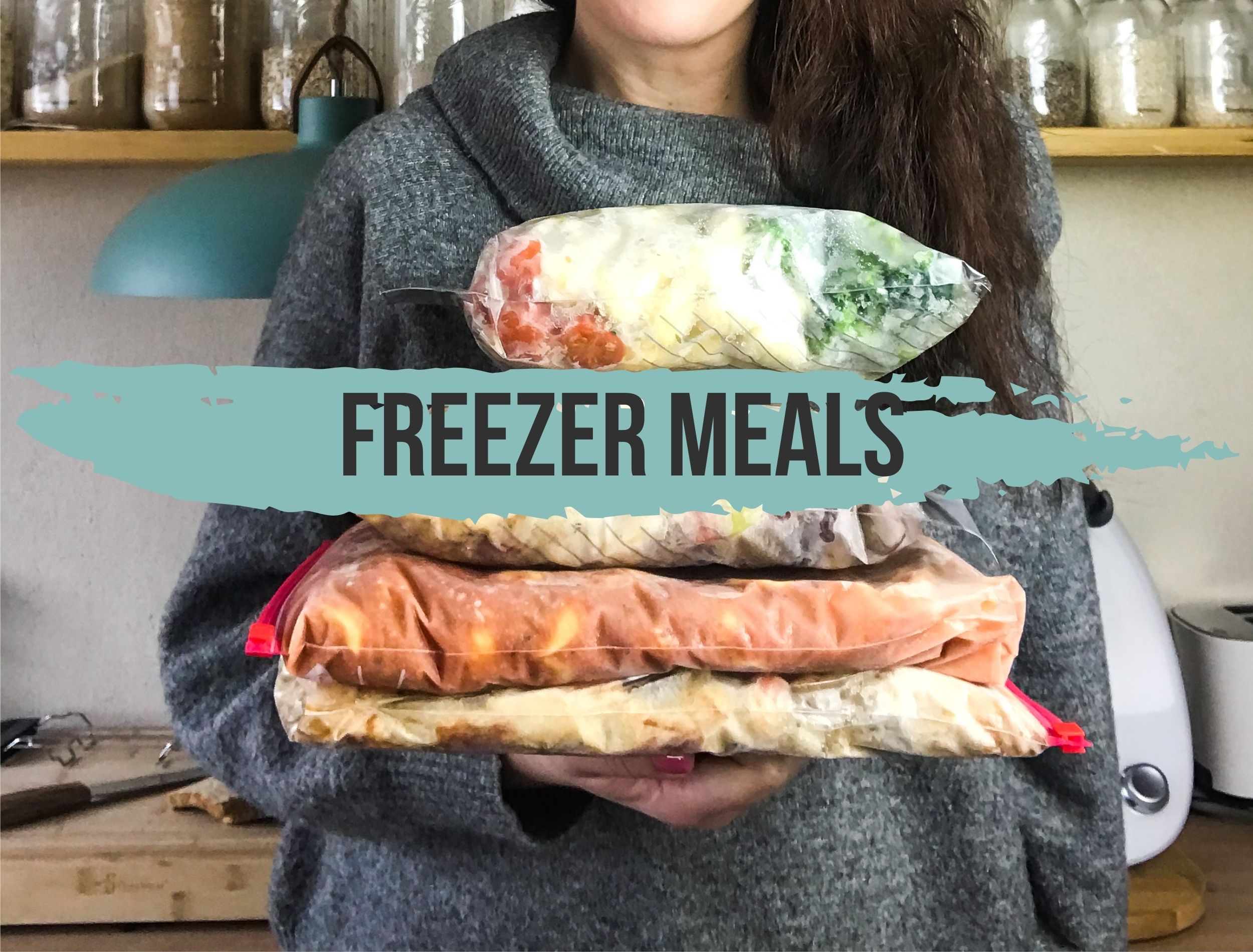Freezer Meals: Das Bild zeigt eine Person, die mehrere eingefrorene Mahlzeiten flach in Gefrierbeuteln in der Hand hält.
